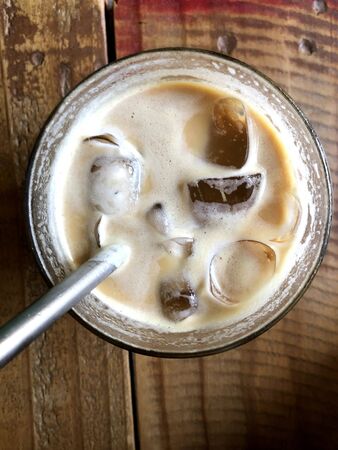 white coffee with ice cubes in a glass on the tableの写真素材