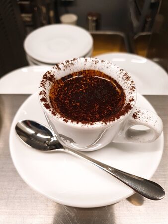 cappuccino with chocolate powder in his bag in a cup on the tableの写真素材