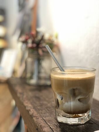 milk coffee with ice cubes and straws on the tableの写真素材