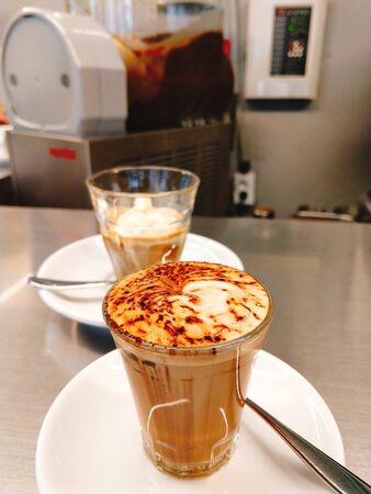 milk coffee with latte and chocolate powder in a glass with motion blurの写真素材