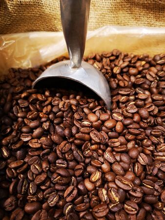 coffee beans in a sack with a coffee spoonの写真素材
