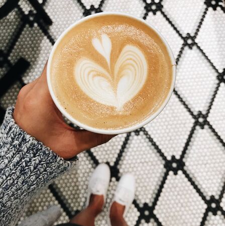 coffee milk with a heart shape from milk in a cup with motion blurの写真素材