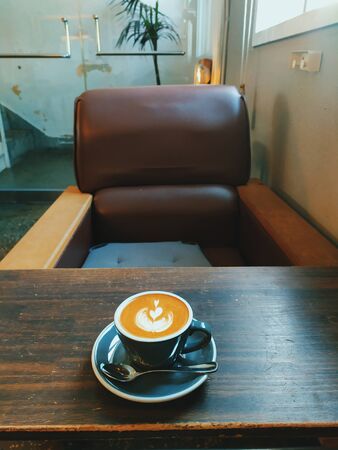 coffee milk with a heart-shaped milk against the background of the tableの写真素材