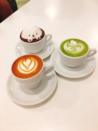 coffee with three different flavors in a cup on the tableの写真素材