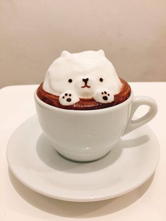 milk coffee with a cute bear-shaped ice cream decorationの写真素材