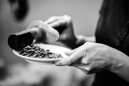 coffee beans are processed by coffee tools on a plate in black and whiteの写真素材