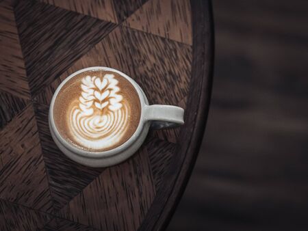 uniquely shaped milk coffee in a cup on a uniquely shaped tableの写真素材