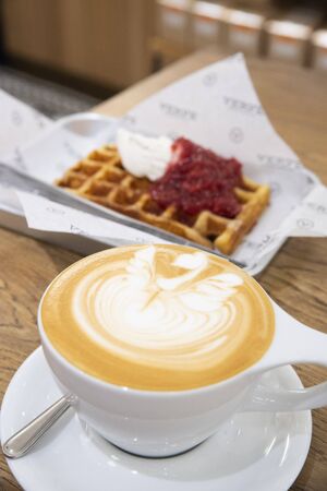 coffee milk with a heart shape and toast bread and sauce on a plateの写真素材