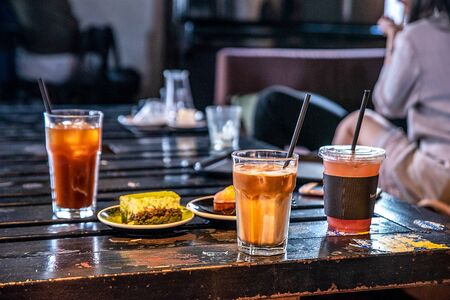 three drinks with straws and bread snacks on the tableの写真素材