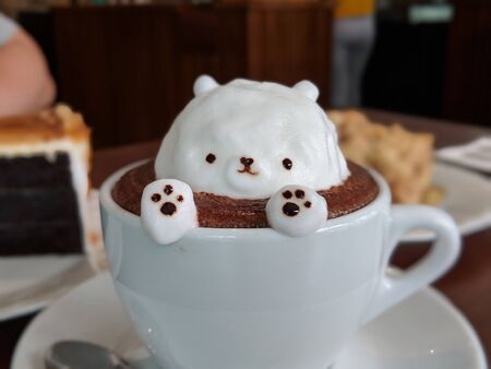 chocolate coffee with bear-shaped cream in a cupの写真素材