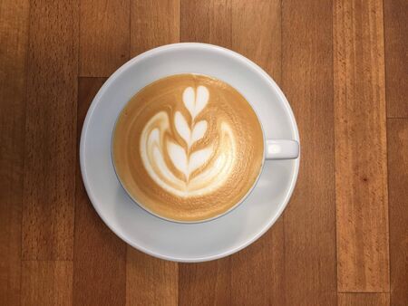 coffee milk with a tree shape in a cup on the tableの写真素材