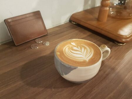 coffee milk with a unique form of milk with a wallet next to itの写真素材