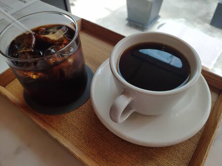iced tea and black coffee in a cup on a trayの写真素材