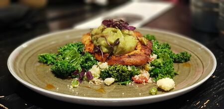 salad with chicken and mayonnaise sauce on a plate on a wooden tableの写真素材