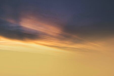 Brilliant yellow sunset and sunrise beautiful over blue clouds with bright yellow sun on a cool...