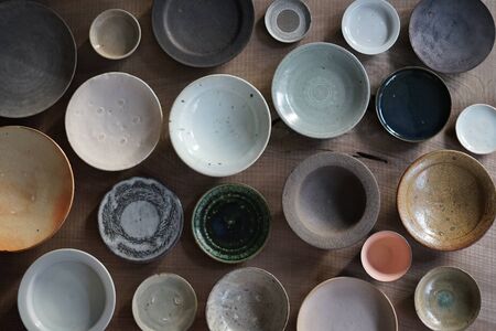 many white and black plate Stacked on a light background on Wood Tableの写真素材