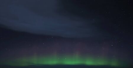 light green and purple northern aurora over Iceland lights and swirls in the sky the Northern lights magnificent phenomenon of the earthの写真素材