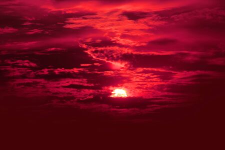 red cloud dawn sky with cloud horizontal lines motion effect on background from sunshine in back.