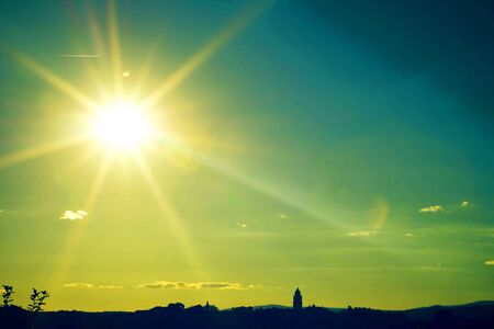 yellow sunset sky and beautiful blue sky background with clouds and sunlight beams on backgroundの写真素材