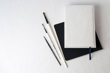 desk organizer notebook,black pen, planner or organizer, mark on white table on backgroundの写真素材
