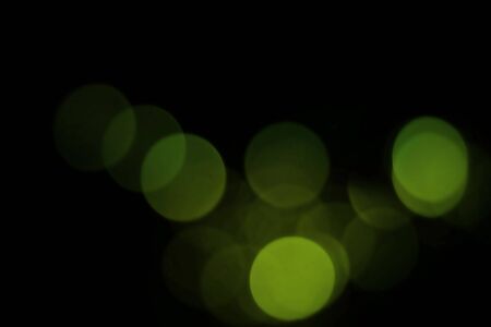 green blur christmas black background.abstract black unfocused blur light dots black background.