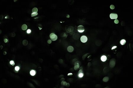 green blur christmas black background.abstract black unfocused blur light dots black background.