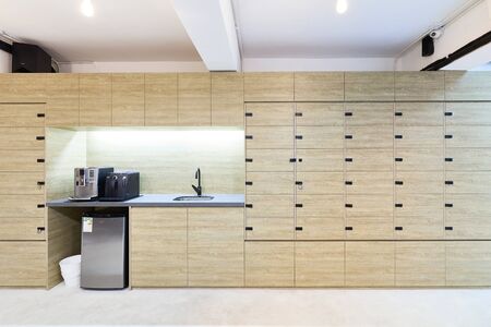 creative co working space office center with cream cupboard,white wallpaper modern open space or shared workplaceの写真素材