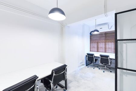 creative co working space office center with black chair,cream table,white wallpaper modern open space or shared workplaceの写真素材