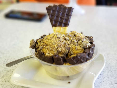 ice cream flavor frozen dessert pattern in white cup hand holding on table background.の写真素材