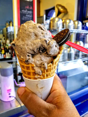 ice cream flavor frozen dessert pattern in white cup hand holding on table background.の写真素材
