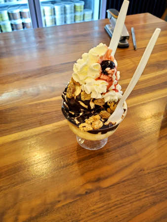 ice cream flavor frozen dessert pattern in white cup hand holding on table background.