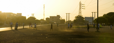 Panoramic image of children playing soccer in the street in Africaのeditorial素材