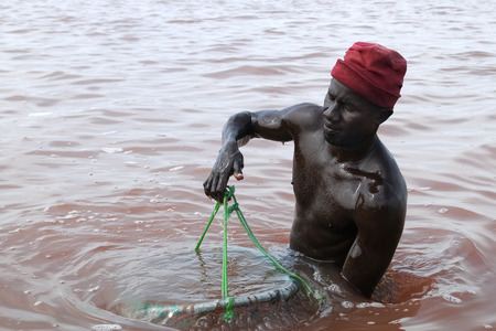 Man working in salt mining industrie at Lake Retba in Senegalのeditorial素材