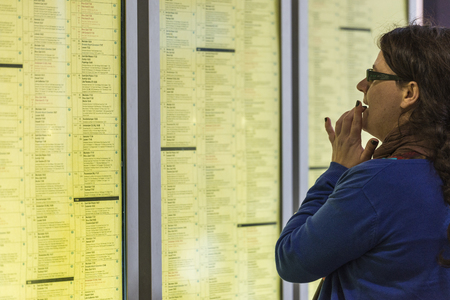 Person looking at the departure board at Antwerpen Centraal Stationのeditorial素材