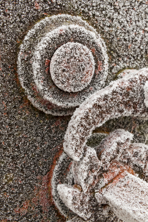 Ice art structures on frozen red colored iron structures along the roadの写真素材