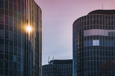 Afternoon lights reflected on the curved glass facade of an office buildingの写真素材