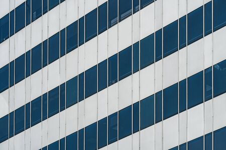 Symmetrical blue windows of an office building made of aluminum and glassの写真素材