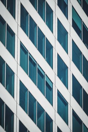 Symmetrical blue windows of an office building made of aluminum and glassの写真素材