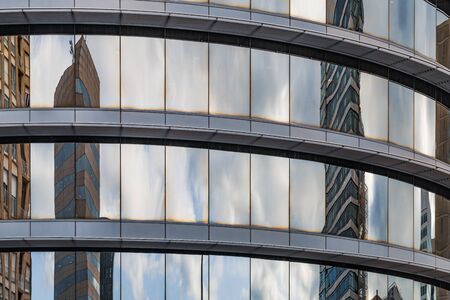 Light reflections on the curved glass of the windows of an office buildingの写真素材