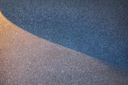 Lights and shadows drawing shapes over a reconstituted stone surfaceの写真素材