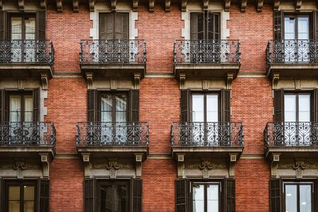 Red brick facade with wrought iron balconiesの写真素材