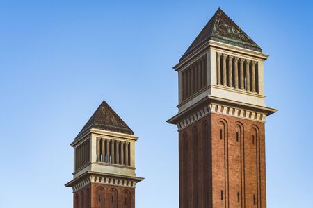 Twin Venetian towers in Barcelona under a blue skyの写真素材