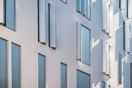 Windows with modern shutters creating light and shadows at the afternoon lightの写真素材