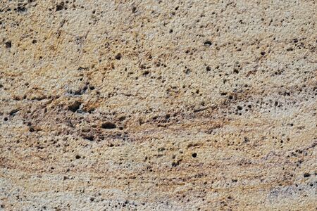 Detail of the rough surface of an eroded travertine marble stoneの写真素材