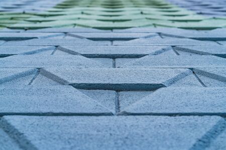 Abstract detail in low angle view of a street wall with geometric pattern design painted in blue and greenの写真素材