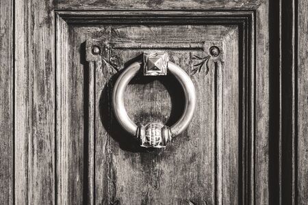 Circular antique iron door knocker of an old wooden doorの写真素材