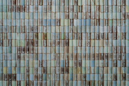 Background of weathered greenish and bluish ceramic tiles wallの写真素材