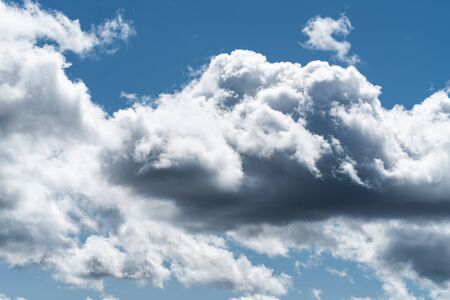 Growing cumulus clouds in a blue sky on a sunny dayの写真素材