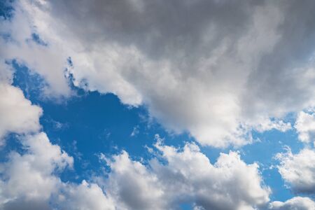 Growing cumulus clouds in a blue sky on a sunny dayの写真素材