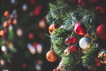 Traditional Christmas tree garland with baubles hanging on branches at the afternoon lightの写真素材